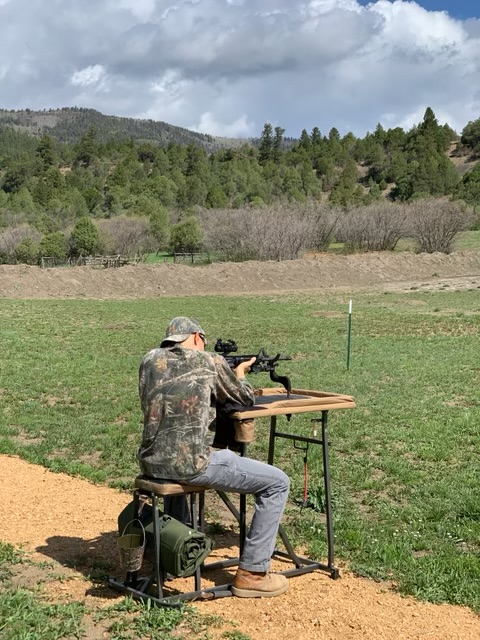 Rifle shooting with mountain backdrop